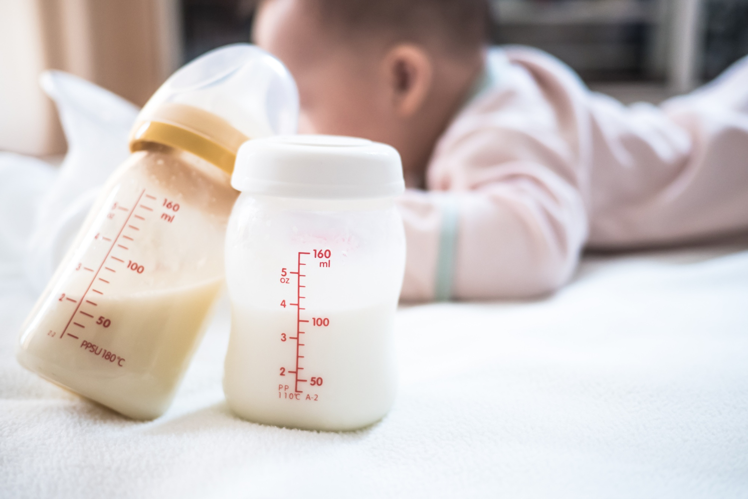Bouteille de lait maternel pour nouveau-né avec bebe en arriere plan